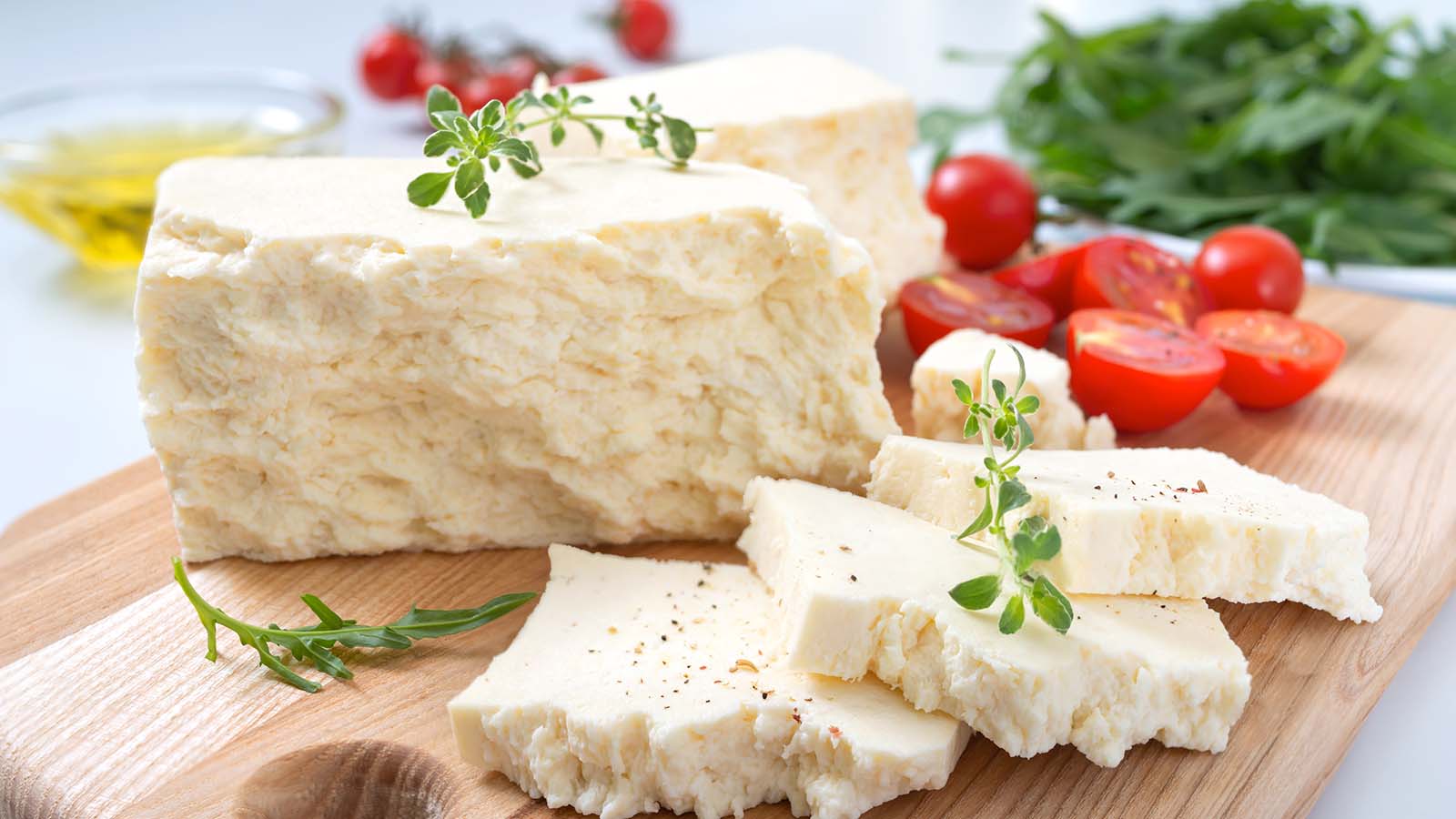 Goat cheese and small red tomatos on wooden pallet