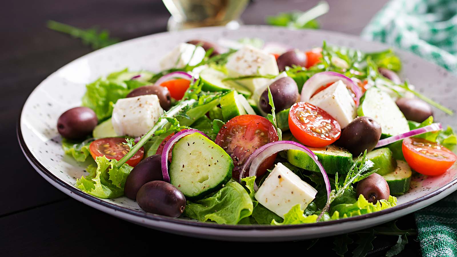Greek salad with feta cheese on white plate