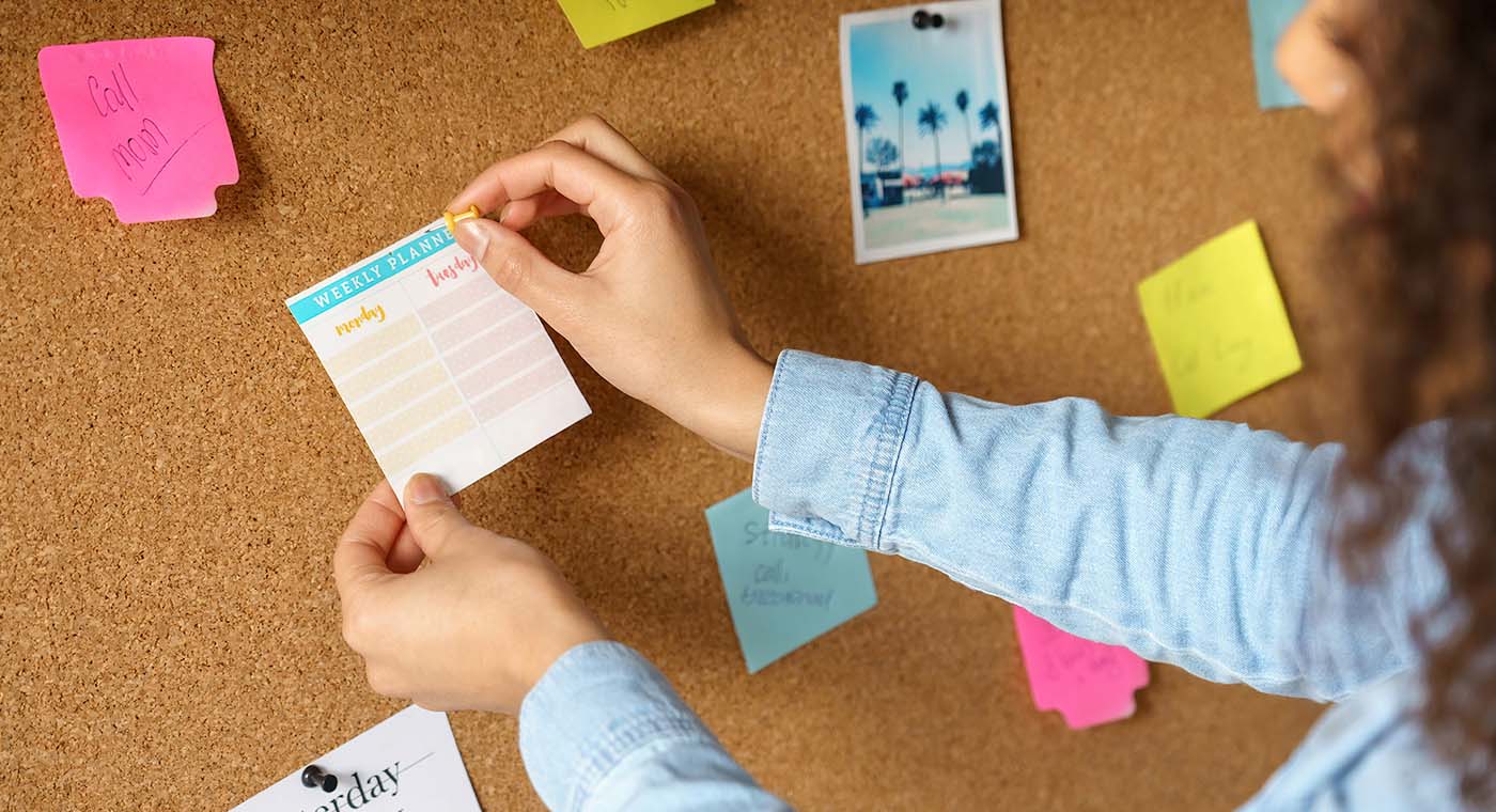 woman placing note on corkboard