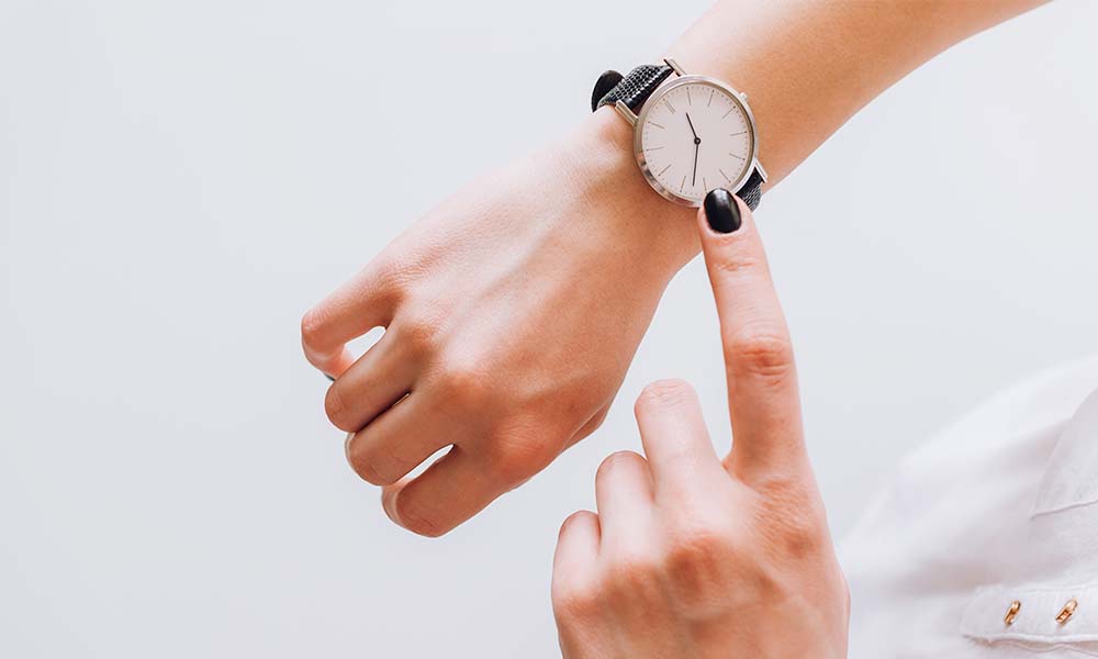 Woman pointing to watch on wrist