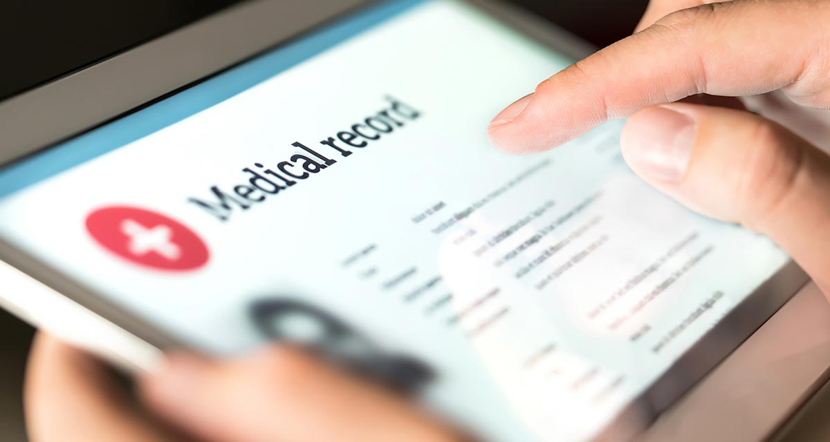 person holding tablet showing medical record information