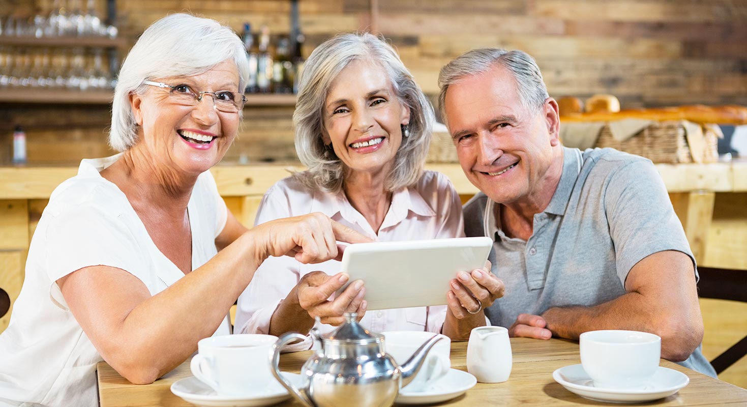 Young blonde woman showing menu selection to elderly woman