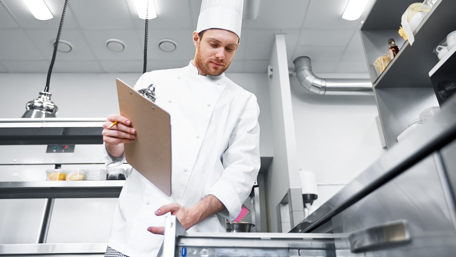 Male chef cook with clipboard doing inventory 