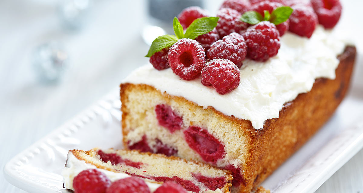 Christmas raspberry cake on white plate with slice cut off