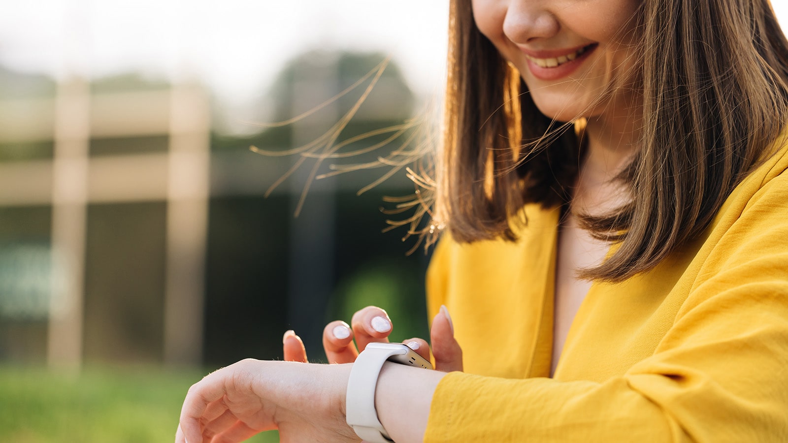 Woman wearing yellow looking at her watch