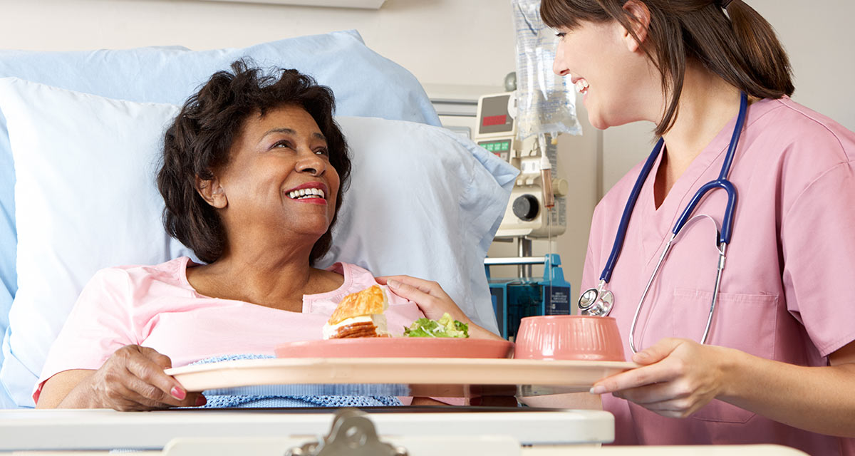 senior-woman-sitting-hospital-bed-tray