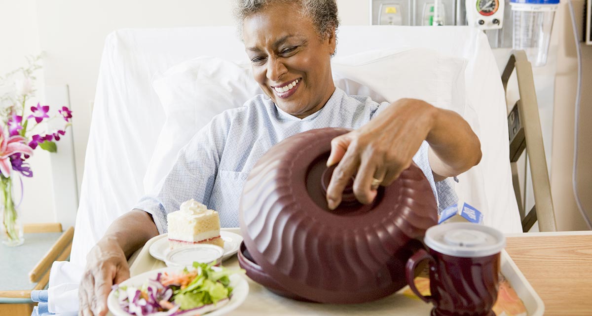 senior-woman-sitting-hospital-bed-tray